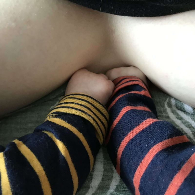 tweeling houdt handjes vast tijdens de borstvoeding